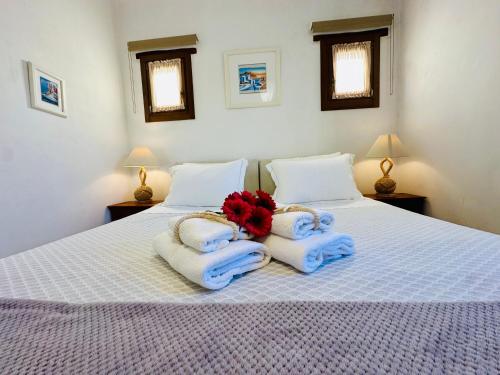 a bedroom with two beds with towels and flowers on them at Divers House in Agrari