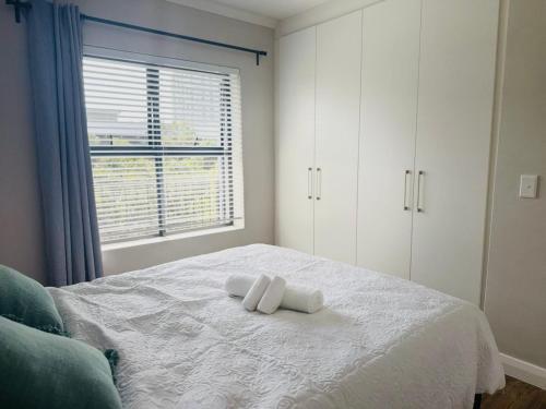 a bedroom with a bed with two towels on it at Manhattan Corner in Cape Town