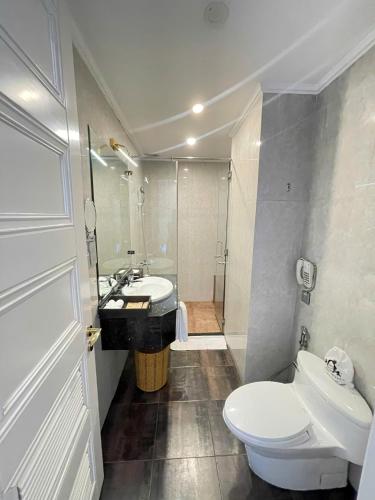 a bathroom with a white toilet and a sink at Samdi Premium - Near Da Nang International Airport in Da Nang