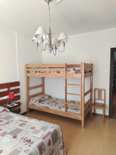 a bedroom with two bunk beds and a chandelier at CASA AZZURRA Domodossola FREE PARKING in Domodossola