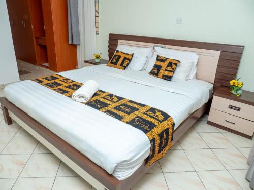 1 dormitorio con 1 cama grande con manta amarilla y negra en Perfect Palm Condos-F16, en Nakuru