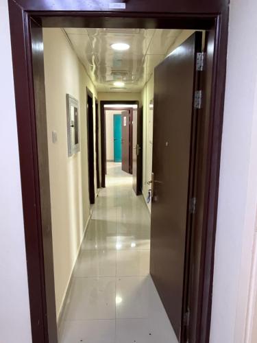 a hallway in a building with a door open at Private double Delight Couple Room in Abu Dhabi