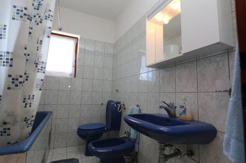 a bathroom with two blue toilets and a sink at Apartment Josip in Risika