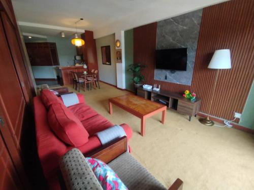 ゲンティンハイランドにあるHomestay at AWANA GENTING HIGH LANDSの赤いソファとテーブルのあるリビングルーム