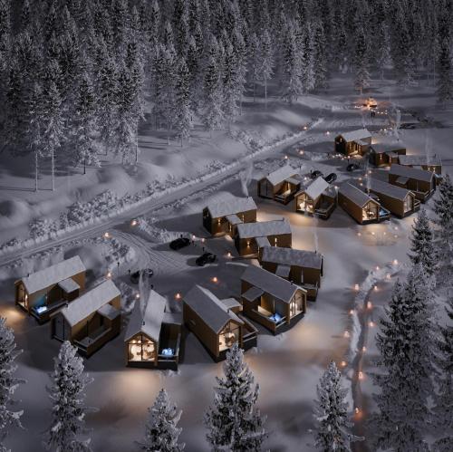 a group of lodges in the snow at night at North Suite Nova by Hilla Villas in Kittilä