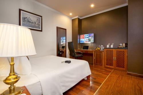 a hotel room with a bed and a desk at Samdi Premium - Near Da Nang International Airport in Da Nang