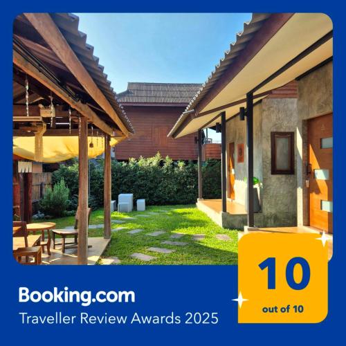 a view of a house with a sign that says travel review awards at Kedthawa Homestay เฮือนนาวา in Ban Cho Lae