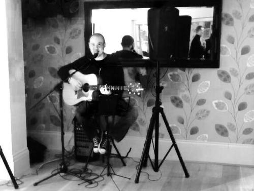a man playing a guitar in front of a mirror at Strawberry Bank Hotel, NEC in Meriden