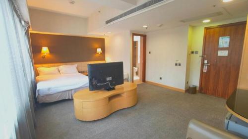 a bedroom with a bed and a television on a table at H1 Hotel in Hong Kong