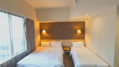a room with two beds and a window at H1 Hotel in Hong Kong