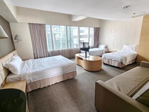 a hotel room with two beds and a window at H1 Hotel in Hong Kong