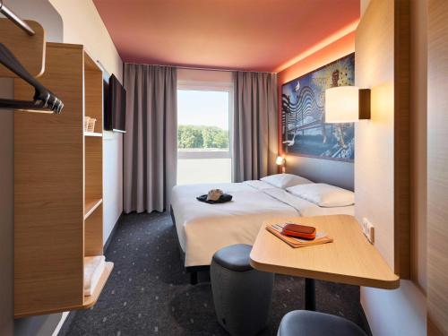 a hotel room with a bed and a table at B&B HOTEL Emmerich in Emmerich