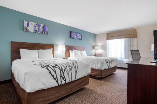 a hotel room with two beds and a window at Sleep Inn & Suites Auburn Campus Area I-85 in Auburn