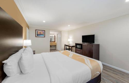 a hotel room with a bed and a flat screen tv at Quality Inn Long Beach - Signal Hill in Long Beach