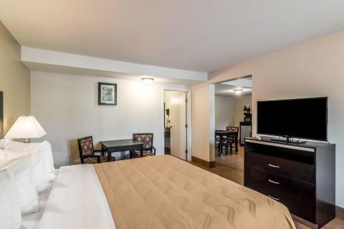 a hotel room with a bed and a flat screen tv at Quality Inn & Suites near Downtown Bakersfield in Bakersfield