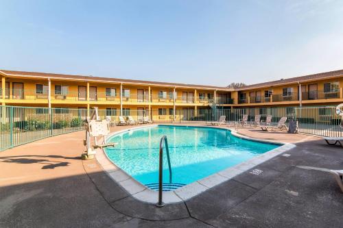 a swimming pool in front of a building at Quality Inn & Suites near Downtown Bakersfield in Bakersfield