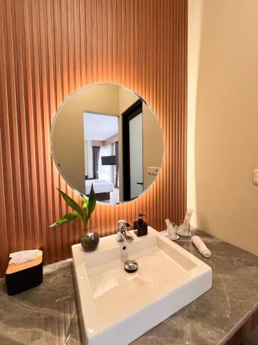a bathroom with a sink and a mirror at M-LIVIN Hotel in Pangkal Pinang