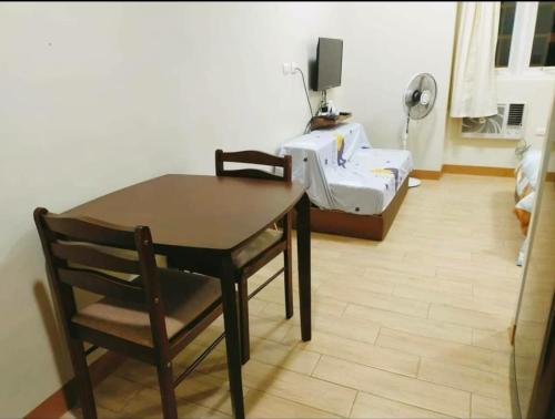 a room with a table and a chair and a bed at Lafayette Park Square with balcony facing pool view in Cari Mayor