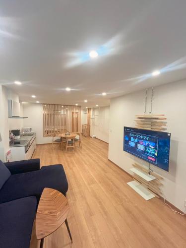a living room with a couch and a tv on a wall at Skytree Luxury Villa - 2025 New, to Skytree, Direct Airport Access in Tokyo