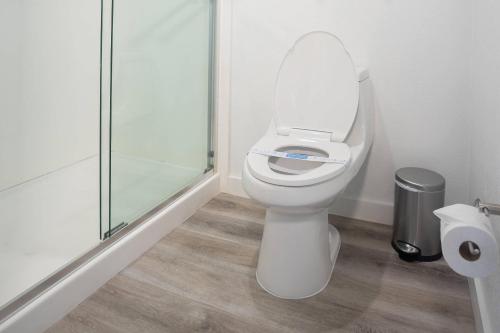 a bathroom with a toilet and a glass shower at DASKK Orlando Hotel near Universal Blvd, an Ascend Collection Hotel in Orlando