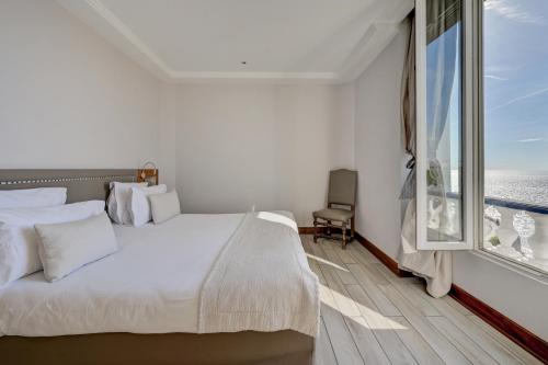 a bedroom with a white bed and a large window at Le Rhul in Marseille