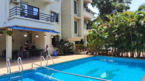 a hotel with a swimming pool in front of a building at Anant Villa & Resorts in Nagaon