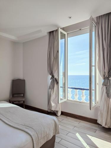 a bedroom with a large window with a view of the ocean at Le Rhul in Marseille