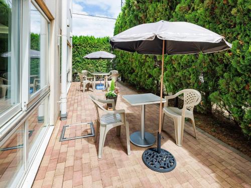 a patio with a table and an umbrella and chairs at Comfort Inn Tsuchiura Ami in Tsuchiura