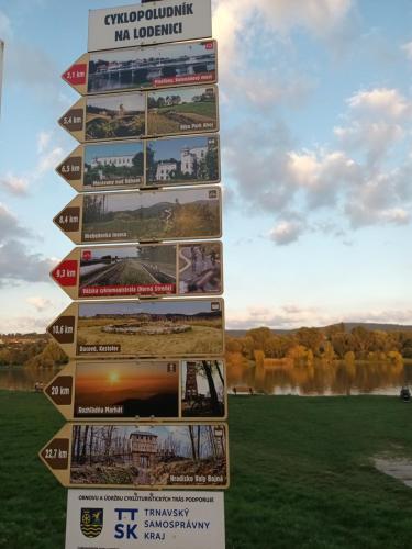 a sign with pictures on it in front of a lake at Apartmán Sĺňava rezort Linea Piešťany in Piešťany