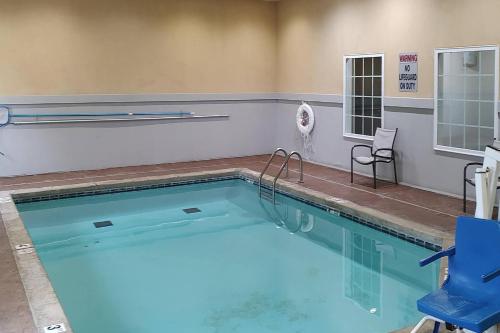 a large swimming pool with a blue chair and a blue chair at Comfort Inn & Suites in Claremore