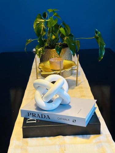 a table with a book and two white pretzels on it at Tubungu- House of Lux& Lush in Matsapha
