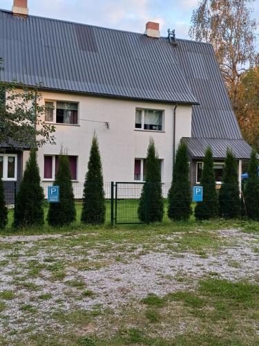 a house with a fence and trees in front of it at Vähikoja majutus in Kose