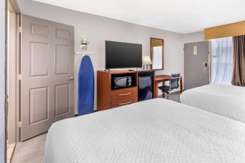 a hotel room with two beds and a flat screen tv at Clarion Pointe Morrow - Atlanta South in Morrow
