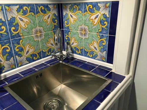 un lavandino in bagno con parete piastrellata blu di Casa Azzurra a Ischia