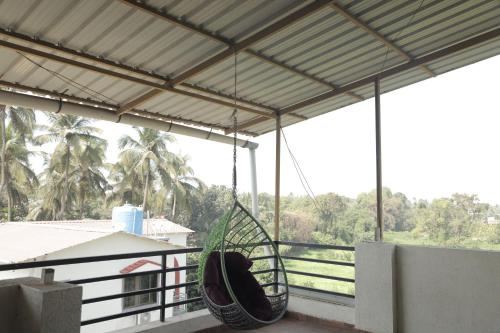 a hammock hanging from a balcony with a view of trees at Anant Villa & Resorts in Nagaon