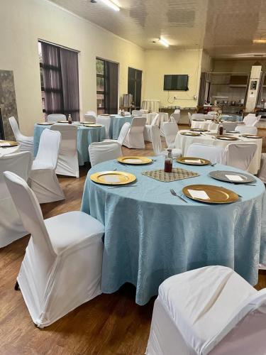 a room with white tables and white chairs at Fuleng Guest House - Quthing in Quthing