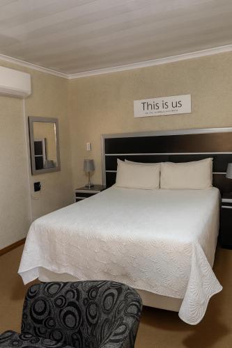 a bedroom with a large bed with a sign that reads this is us at Fuleng Guest House - Quthing in Quthing