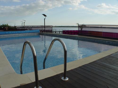 - une piscine avec des barres d'appui en métal près de l'eau dans l'établissement Sophia Sunset Lakeview Mamaia Apartment, à Mamaia