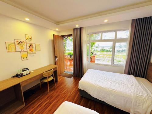 a bedroom with a desk and a bed and a window at Villa Sea in Trà Cổ