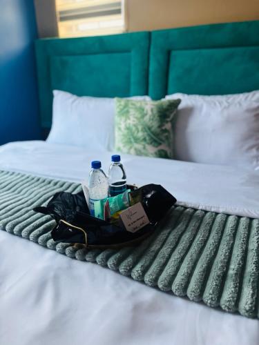a bag and water bottles on a bed at Tubungu- House of Lux& Lush in Matsapha