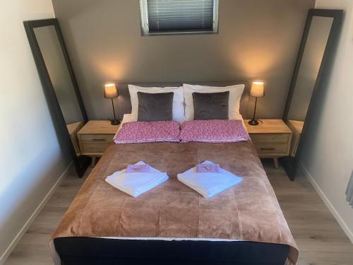 a bedroom with a large bed with two pillows at Trollstova in Sogndal