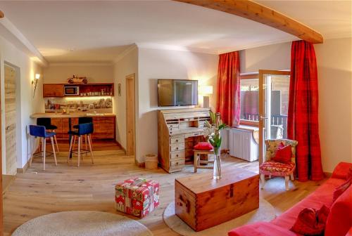 a living room with a couch a table and a kitchen at Serviced Apartments VILLA LICHT in Kitzbühel