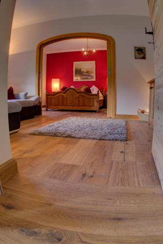 a large room with two beds and a red wall at Serviced Apartments VILLA LICHT in Kitzbühel