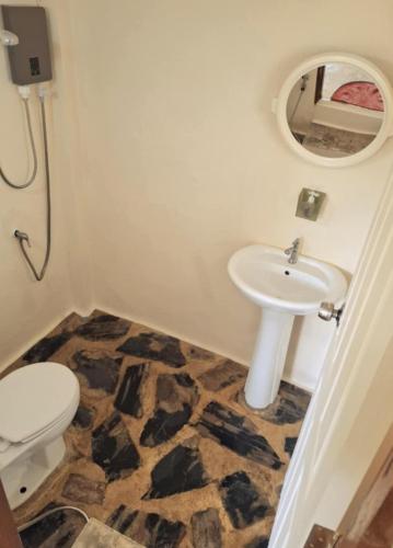 a bathroom with a sink and a toilet and a mirror at Oasis Pai Resort in Pai