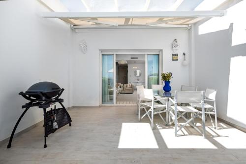 a living room with a grill and a table and chairs at Casa adosada en primera línea de playa, Estepona in Estepona