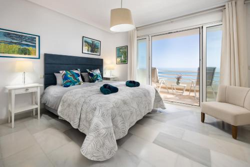 a bedroom with a bed and a view of the ocean at Casa adosada en primera línea de playa, Estepona in Estepona