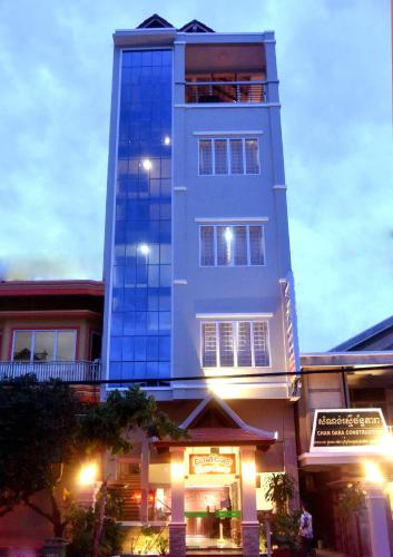 a tall blue building with a store in front of it at Happy​​ Family Guesthouse in Kampot