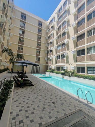 a swimming pool in front of a building at Family-Friendly 2BR Staycation near Nuvali & Enchanted Kingdom in Puting Kahoy