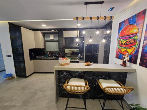 eine Küche mit einer Theke mit zwei Stühlen in der Unterkunft Stylish Apartment in New Admin Capital Celia Cairo in Madīnat al Amal