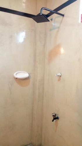 a bathroom with a shower with a toilet on the wall at Natures Villa in Weligama